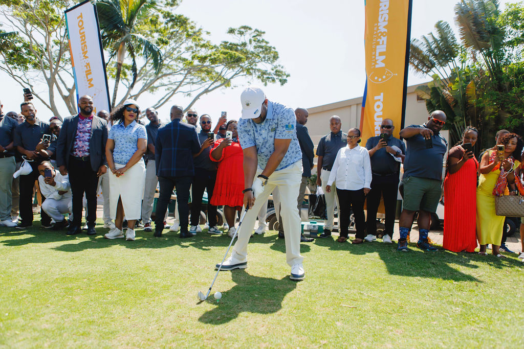 Guests gather around a golfer preparing a shot at a previous Cup event